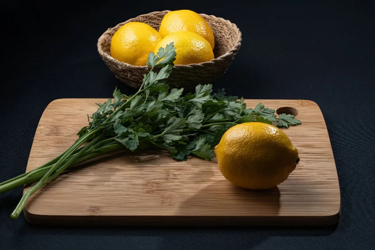 Hierbas frescas en la cocina sobre una tabla de madera con albahaca, cilantro, romero, perejil y hierbabuena listas para cocinar.