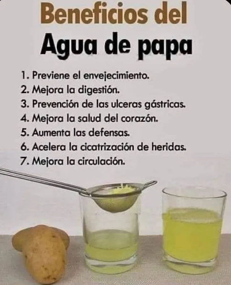 Papa fresca junto a un vaso de agua de papa sobre una mesa de cocina con luz natural.