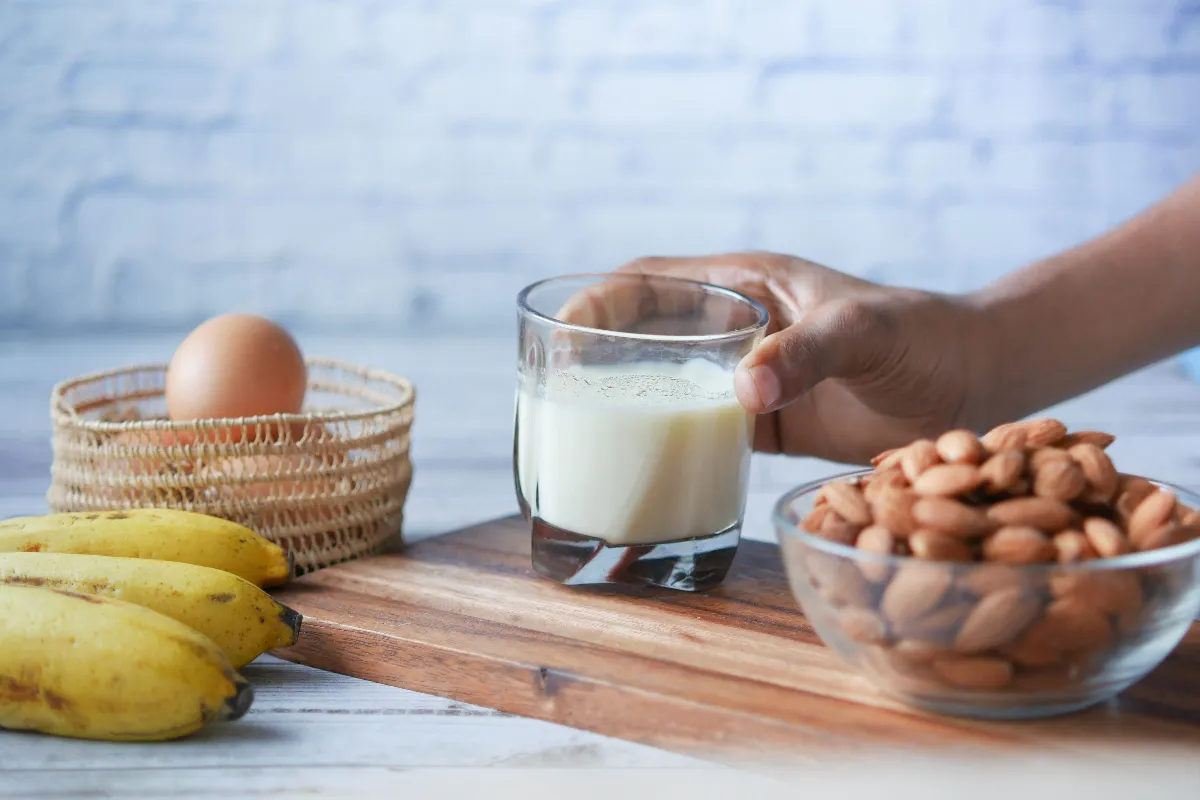 Persona mayor revisando alimentos ricos en vitamina B12 como pescado, huevos y lácteos, junto a un frasco de suplemento, representando la deficiencia de vitamina B12 después de los 50.